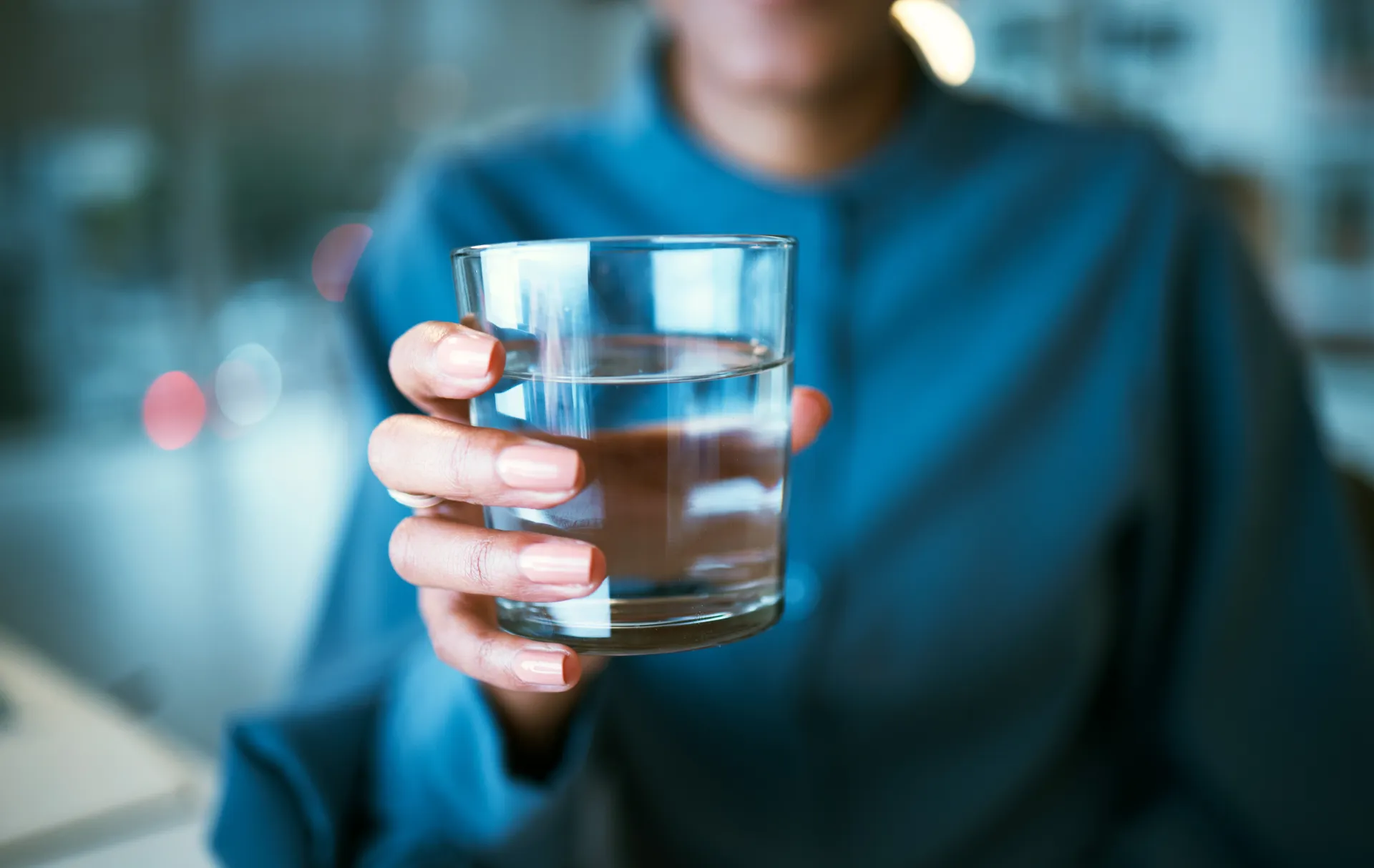 Sinises särgis naine ulatab klaasi vett „Culligan“ veeautomaadist.